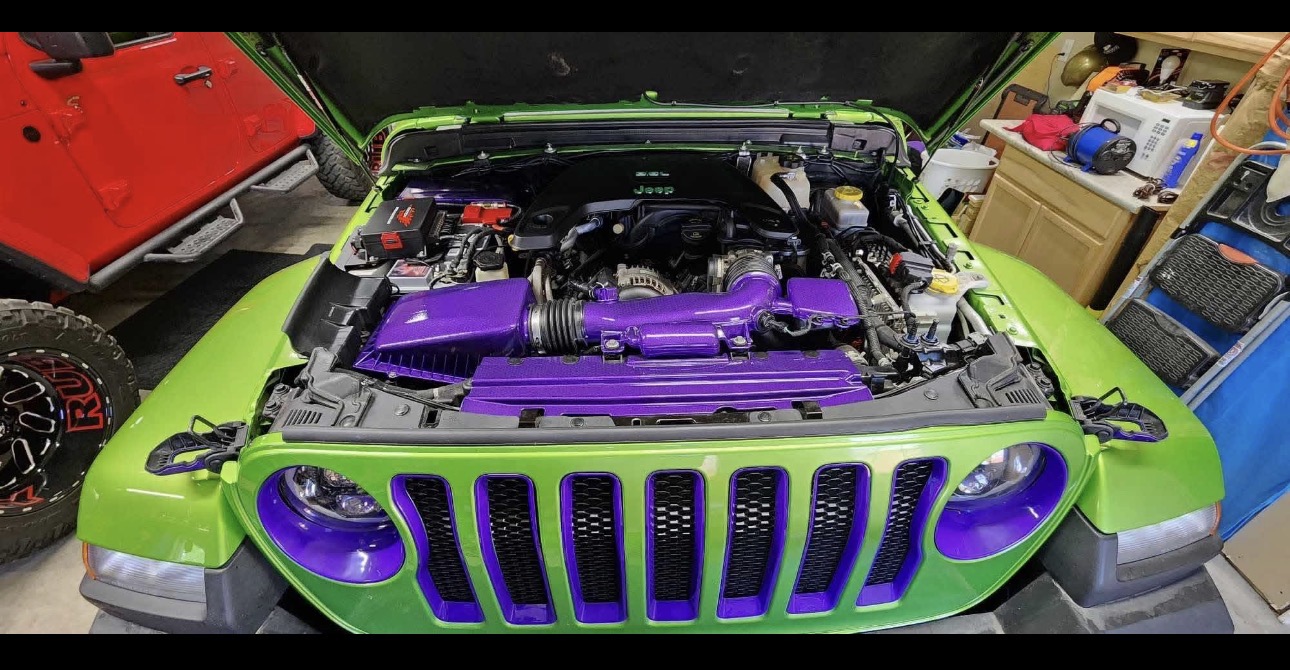 Bright green Jeep with custom purple hydro-dipped engine cover and grille accents